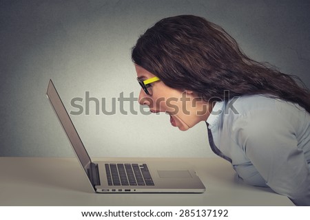 Angry furious businesswoman working on computer, screaming. Negative human emotions, facial expressions, feelings, aggression, anger management issues concept