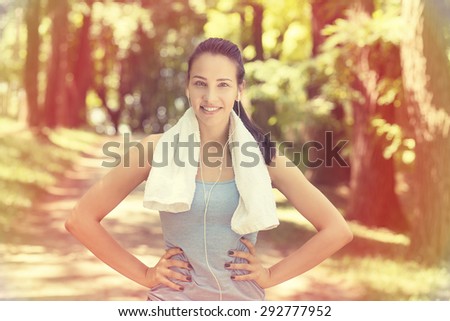 Portrait young attractive smiling fit woman with white towel resting after workout sport exercises outdoors on a background of park trees. Healthy lifestyle well being wellness concept
