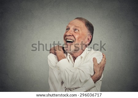 Closeup portrait confident smiling man holding hugging himself isolated on grey wall background. Positive human emotion, facial expression, feeling, reaction, attitude. Love yourself concept