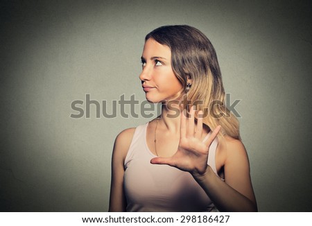 Closeup portrait young annoyed angry woman with bad attitude giving talk to hand gesture with palm outward isolated grey wall background. Negative human emotion face expression feeling body language