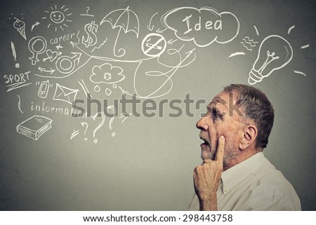 Closeup side profile portrait thoughtful senior man has many ideas looking up isolated on gray wall background