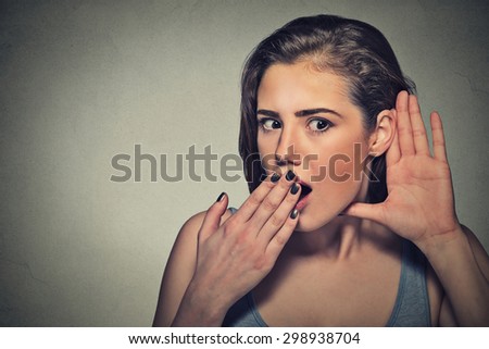 Closeup portrait surprised young nosy woman hand to ear gesture carefully intently secretly listening juicy gossip conversation news privacy violation isolated grey background. Human face expression