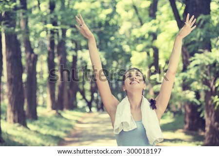 Young fit woman arms raised up to sky celebrating freedom. Positive human emotion feeling life perception success peace of mind concept. Free Happy girl in summer forest enjoying nature after workout