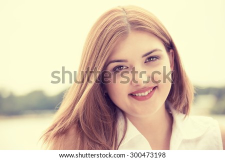 Portrait summer young girl outdoors. Closeup happy woman smiling on sunny summer or spring day outside in park by lake.