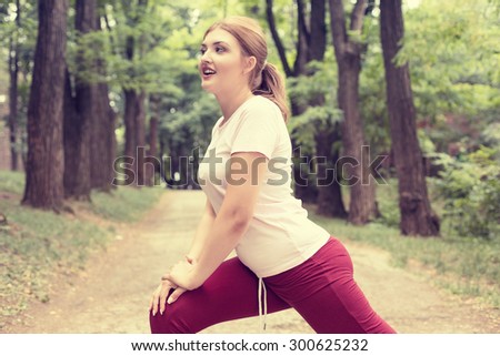Fitness woman stretching exercises on fresh air. Beautiful sportswoman exercising outdoors in park on summer spring day. Young sporty girl stretching muscles before jogging