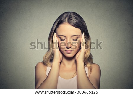 Closeup portrait stressed sad young woman eyes closed hands touching head isolated on gray wall background