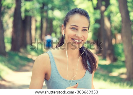 Portrait running young woman. Female runner jogging during outdoor workout in park on spring summer day. Beautiful fit girl. Attractive fitness model outdoors. Weight loss healthy lifestyle concept