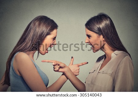 Side profile portrait two angry upset women blaming each other for something wrong isolated on gray wall background. Negative human emotion facial expression. Interpersonal conflict