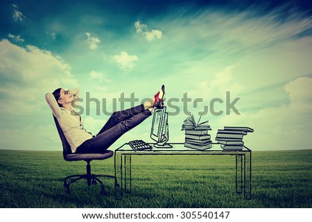 young businesswoman relaxing sitting in the office in the middle of a green meadow. Stress free working environment concept