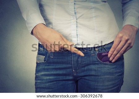young woman ready for date pointing at condom in her pocket