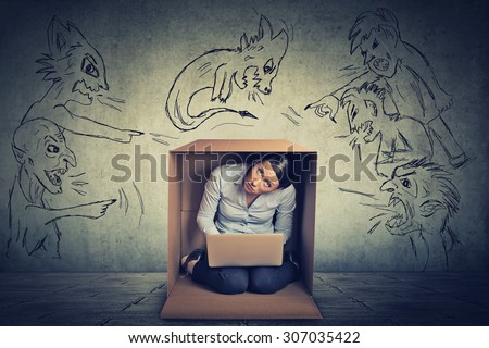 Bad evil men pointing at stressed woman. Desperate scared businesswoman hiding in a box working on laptop grey office wall background. Negative human emotions face expression feelings life perception