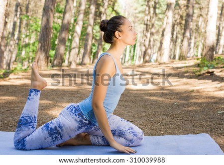 Stretching woman in outdoor exercise happy doing yoga stretches after running. Beautiful happy sport fitness model outside on summer spring day