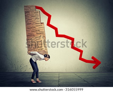 Young woman carrying heavy boxes full of financial debt walking along gray wall background