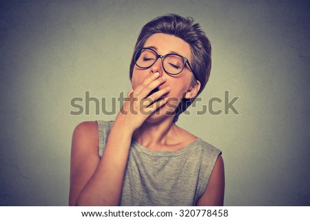 It is too early for meeting. Closeup portrait headshot sleepy young woman with hand over open mouth yawning eyes closed looking bored isolated gray background. Face expression emotion body language