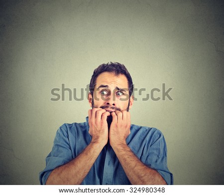 Portrait anxious young man biting his nails fingers freaking out