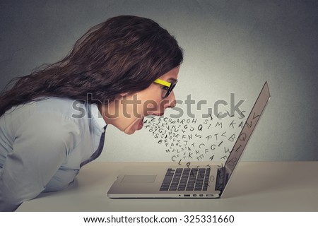 Angry furious businesswoman working on computer, screaming with alphabet letter coming out of open mouth. Negative human emotions, facial expressions, feelings, anger management issues concept