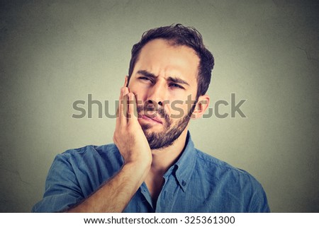 young man with a toothache tooth pain