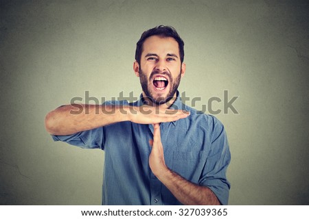 Young man showing time out hand gesture, frustrated screaming to stop isolated on grey wall background. Too many things to do overwhelmed. Human emotions face expression reaction