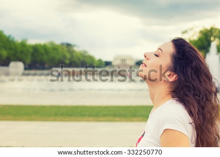 Side profile woman smiling looking up to blue sky, celebrating enjoying freedom. Positive human emotion face expression feeling life perception success, peace of mind concept. Free happy girl