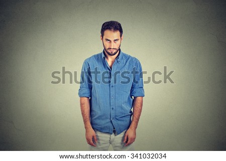 Sad lonely young man with no motivation in life looking down has no energy depressed isolated on gray wall background. Human emotions face expressions