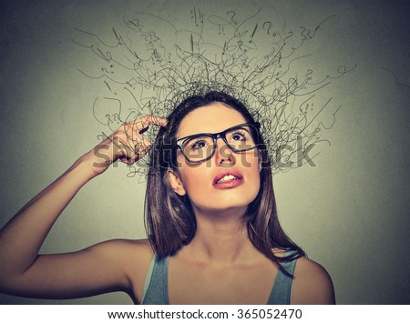 Closeup portrait young woman scratching head, thinking daydreaming with brain melting into lines question marks looking up isolated on gray background. Human facial expressions, emotion feeling sign