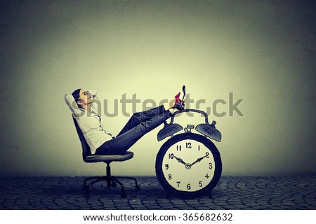 Happy young business woman relaxing sitting in her office. Stress free time management concept