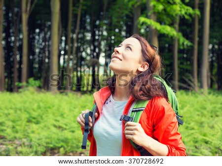 Woman hiker in forest smiling looking up enjoying freedom. Positive human emotion face expression feeling life perception success, peace of mind concept. Free happy girl