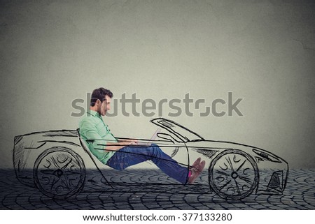 Driverless self driving car technology concept. Side profile young handsome man using laptop computer while driving a car