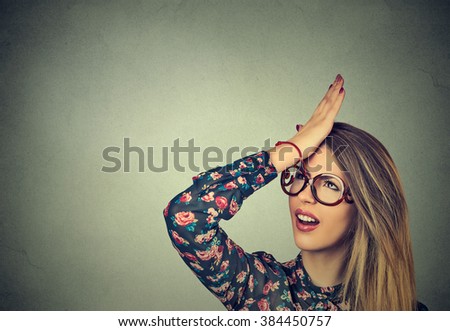 Regrets wrong doing. Closeup portrait silly young woman, slapping hand on head having duh moment isolated on gray background. Negative human emotion facial expression feeling, body language, reaction