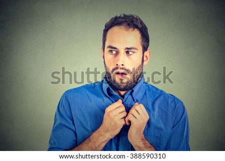 Closeup portrait nervous stressed young man student feels awkward looking away sideway anxiously craving something isolated gray wall background. Human emotion face expression feeling body language