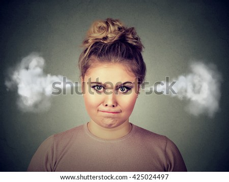 Closeup portrait of angry young woman, blowing steam coming out of ears, about to have nervous atomic breakdown isolated on black background. Negative human emotion facial expression feelings attitude