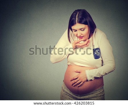 Sick pregnant young woman with nausea morning sickness about to throw up. Health care and unpleasant symptoms of pregnancy concept
