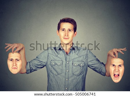 Smiling man holding two different face emotion masks