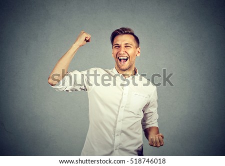 Happy successful student, business man winning, fists pumped celebrating success isolated grey wall background. Positive human emotion facial expression. Life perception, achievement