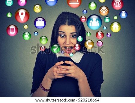 communication technology mobile high tech concept. Closeup surprised young woman using texting on smartphone with social media application symbols icons flying out of screen isolated gray background