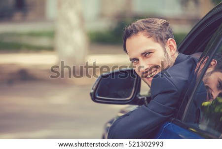 Closeup portrait happy smiling young man buyer sitting in his new car excited ready for trip. isolated outside dealer dealership lot office. Personal transportation auto purchase concept