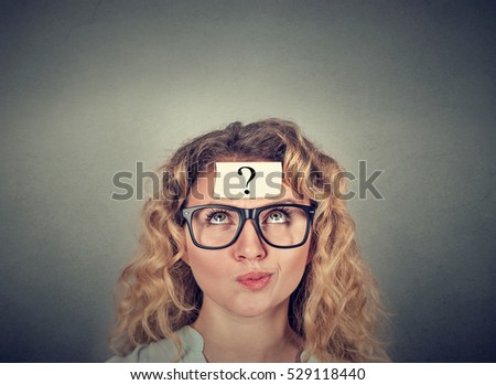 thinking confused woman with question mark on gray wall background