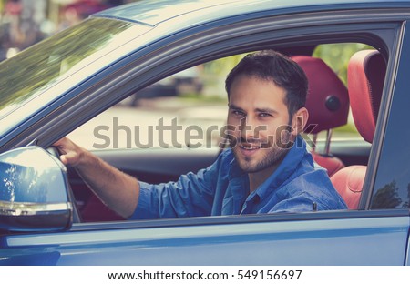 Happy man with hands on wheel driving new car