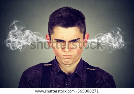 Angry man, blowing steam coming out of ears, about to have nervous breakdown isolated on gray background. Negative human emotions facial expression