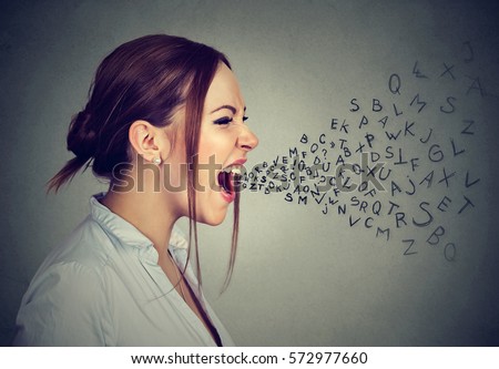 Side profile angry woman screaming with alphabet letters flying out of wide open mouth isolated on gray wall background