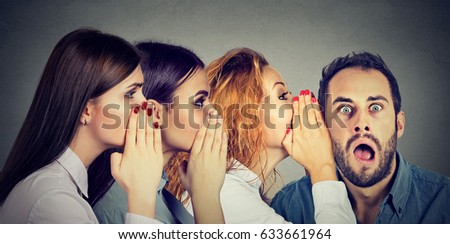 Three young women whispering each other and tho the shocked astonished man in the ear. Word of mouth communication concept. Human emotion face expression reaction