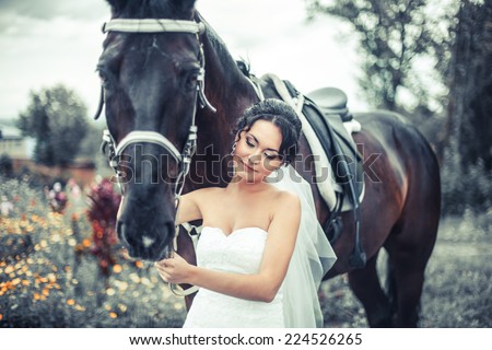 Young woman in white dress standing with horse