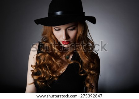Beautiful Lonely Woman on the Dark Background of Dark Wall