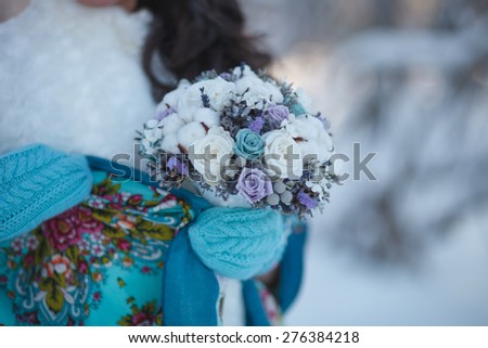Winter Wedding bouquet. Bride in beautiful winter mittens holds a wedding winter bouquet.