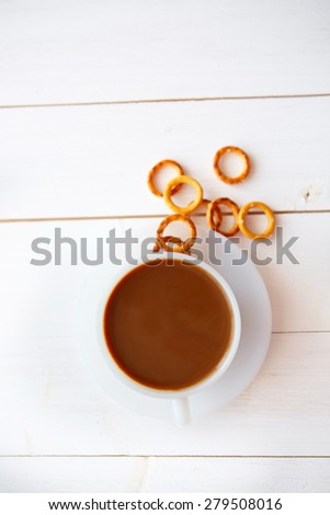 White coffee cup with rich coffee  on a white wooden table