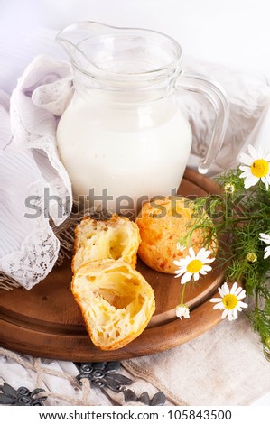 Jug with milk, bread and wild flowers on a white background
