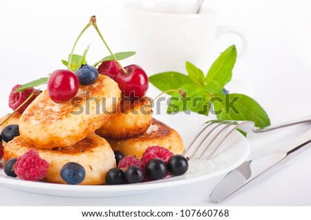 Cheese pancakes with forest berries and cup of coffee