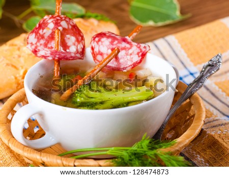 Vegetable soup with salty straws and raw smoked sausage