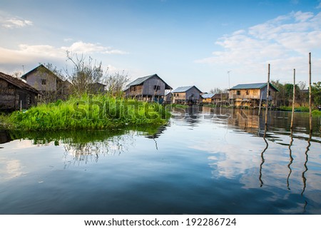 Ancient houses and their reflection in the water on the Inle Lake, Myanmar