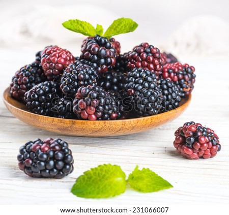 Ã?Â�?unch of wild berries and mint on a wooden board